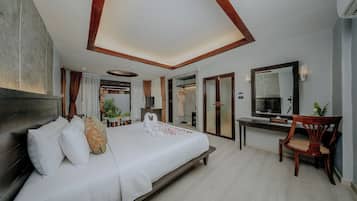 Habitación de hotel con una cama grande, un escritorio, una silla, un espejo y vistas al exterior.