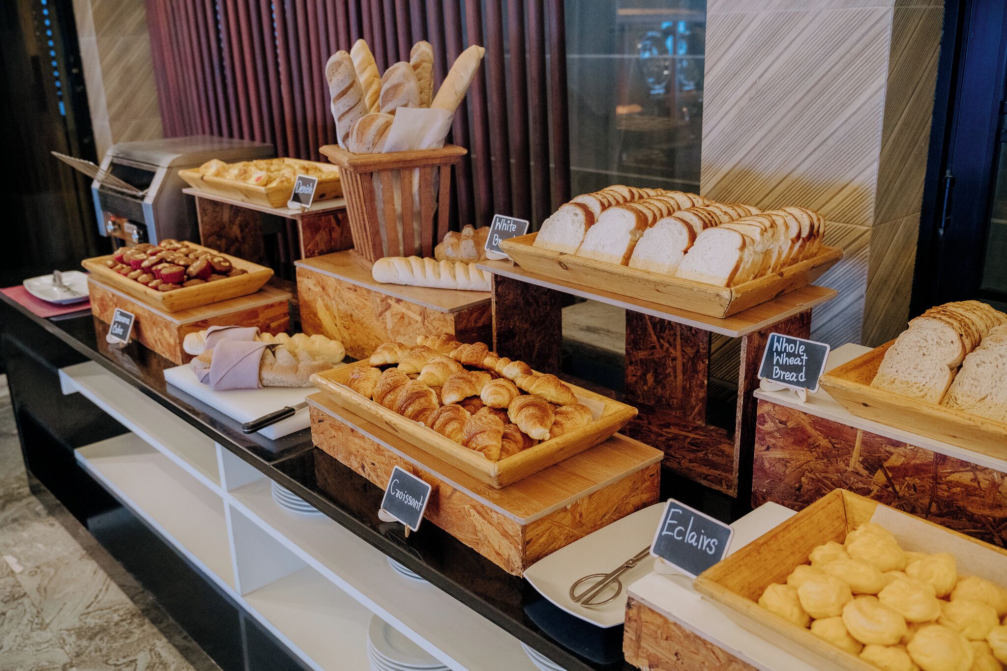 Vitrine de uma padaria com diversos pães e doces.
