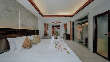 Une chambre d’hôtel dotée d’un grand lit, d’une tête de lit en bois, d’un téléviseur à écran plat, d’une armoire et d’une salle de bain avec douche et toilettes.