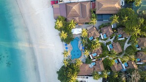 An aerial view of a resort with a swimming pool, lounge chairs, and palm trees. - Railay Bay Resort and Spa (Krabi)