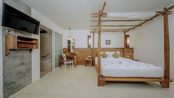 A room with a bed, a desk, a TV, and a bathroom.