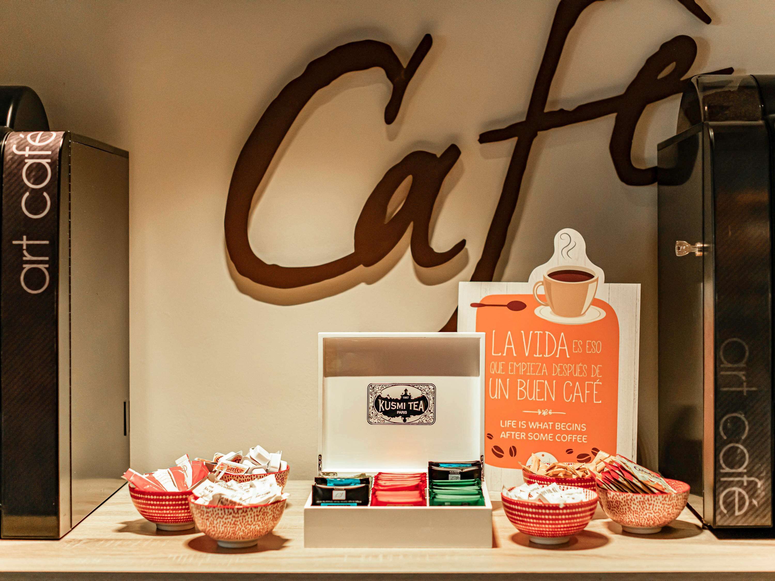 Una exhibición de productos de café y un letrero con el texto "La Vida Es Que Empieza Después De Un Buen Cafe" en un café.
