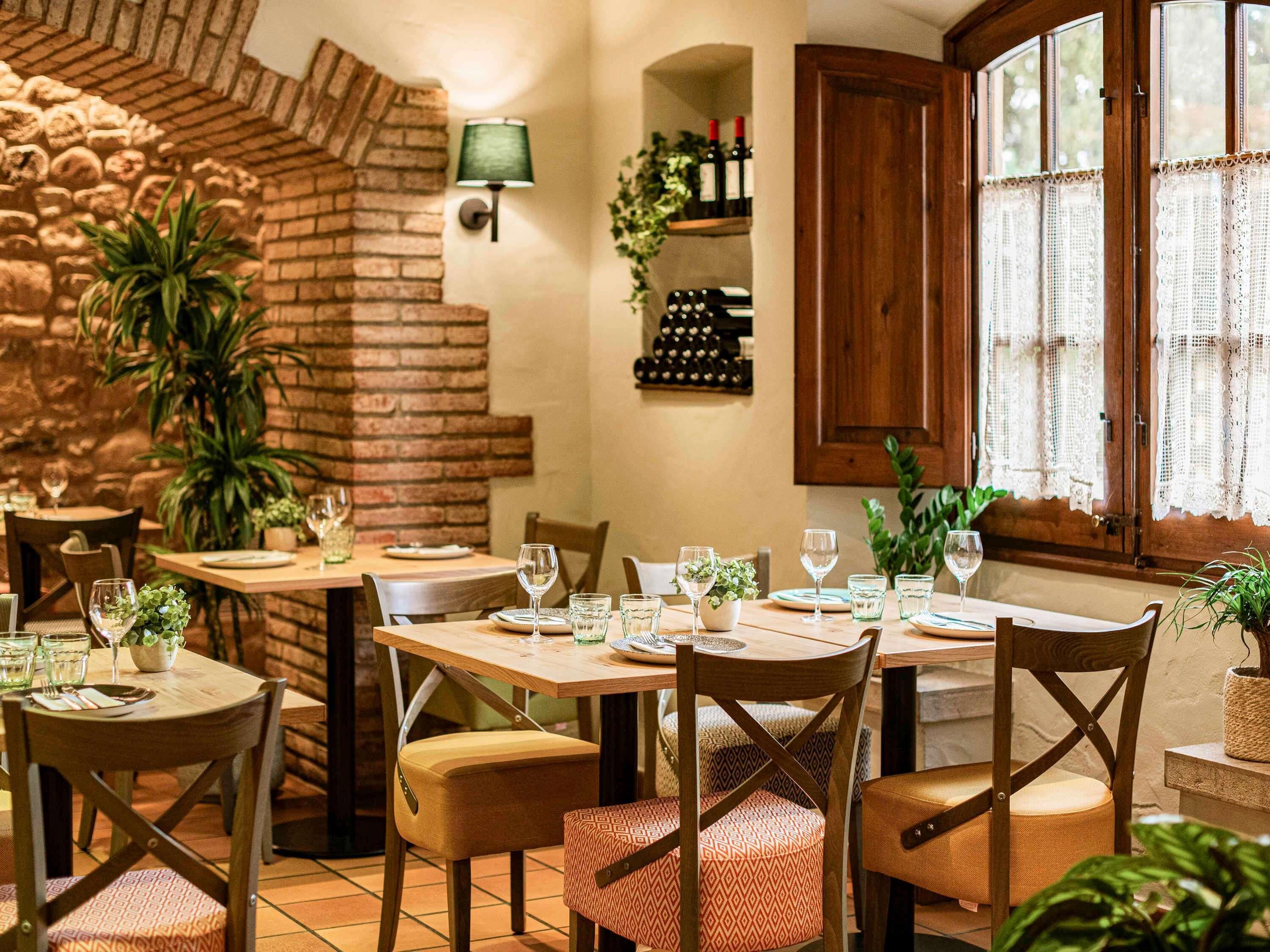 A restaurant with brick walls, wooden tables, and chairs.