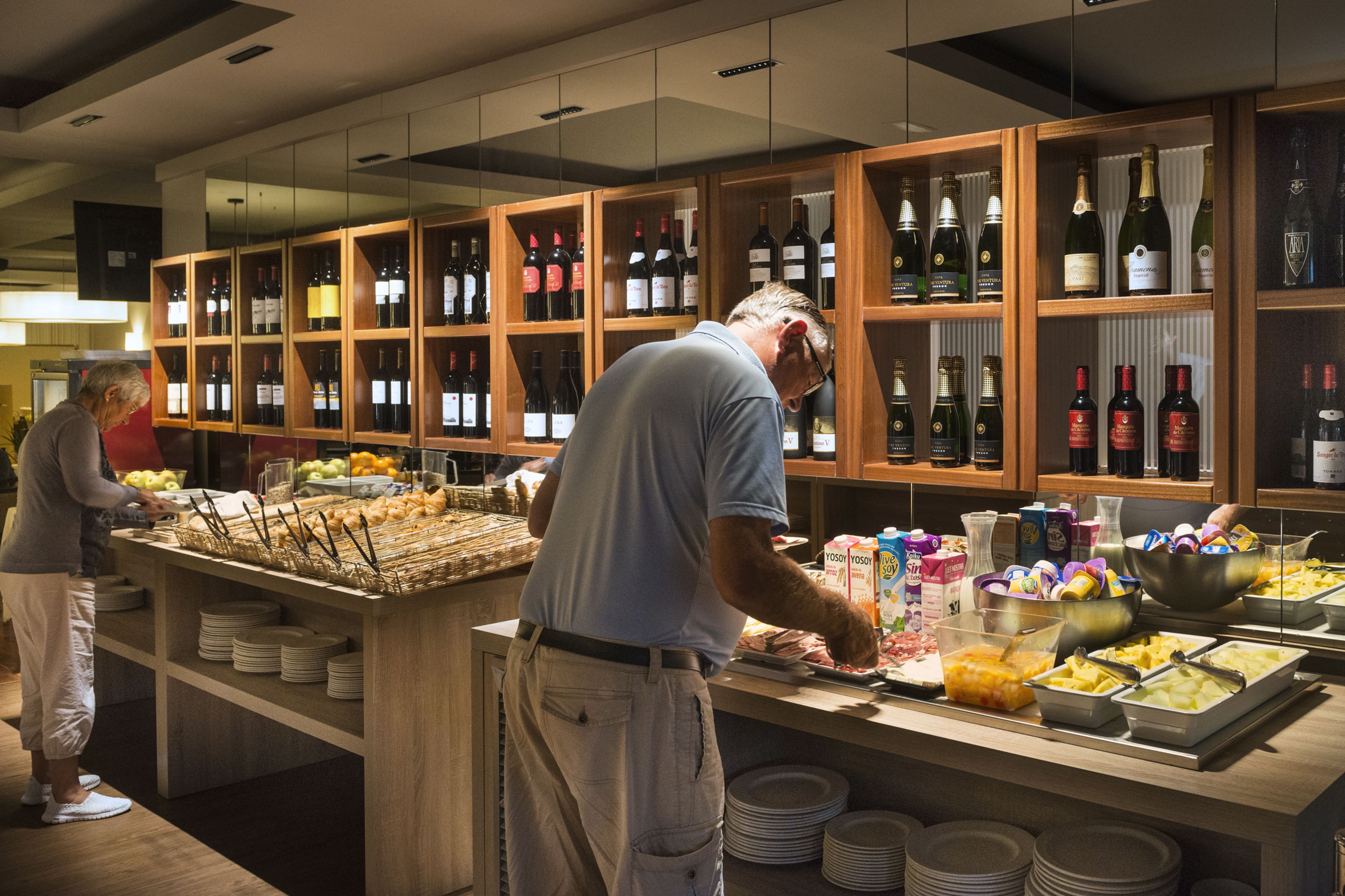 A buffet setup with various food items and a wine selection.