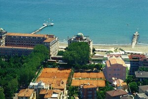 Vista aérea de una ciudad costera con edificios, un puerto deportivo y una playa.
