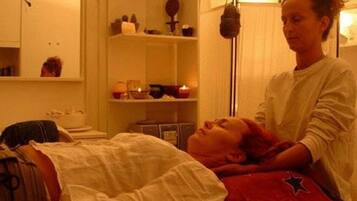 Guests can enjoy a rejuvenating massage in this serene space, complete with a comfortable bed and soothing ambiance.