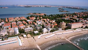 Vista aérea de una ciudad costera con playa, edificios y una extensa masa de agua.