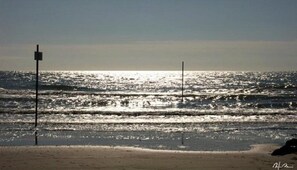 A beach with a clear view of the ocean and a sandy shore.