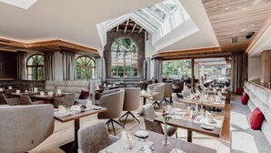 A spacious restaurant with high ceilings, large windows, and a modern interior design. - Hotel Elisabeth (Kirchberg in Tirol)