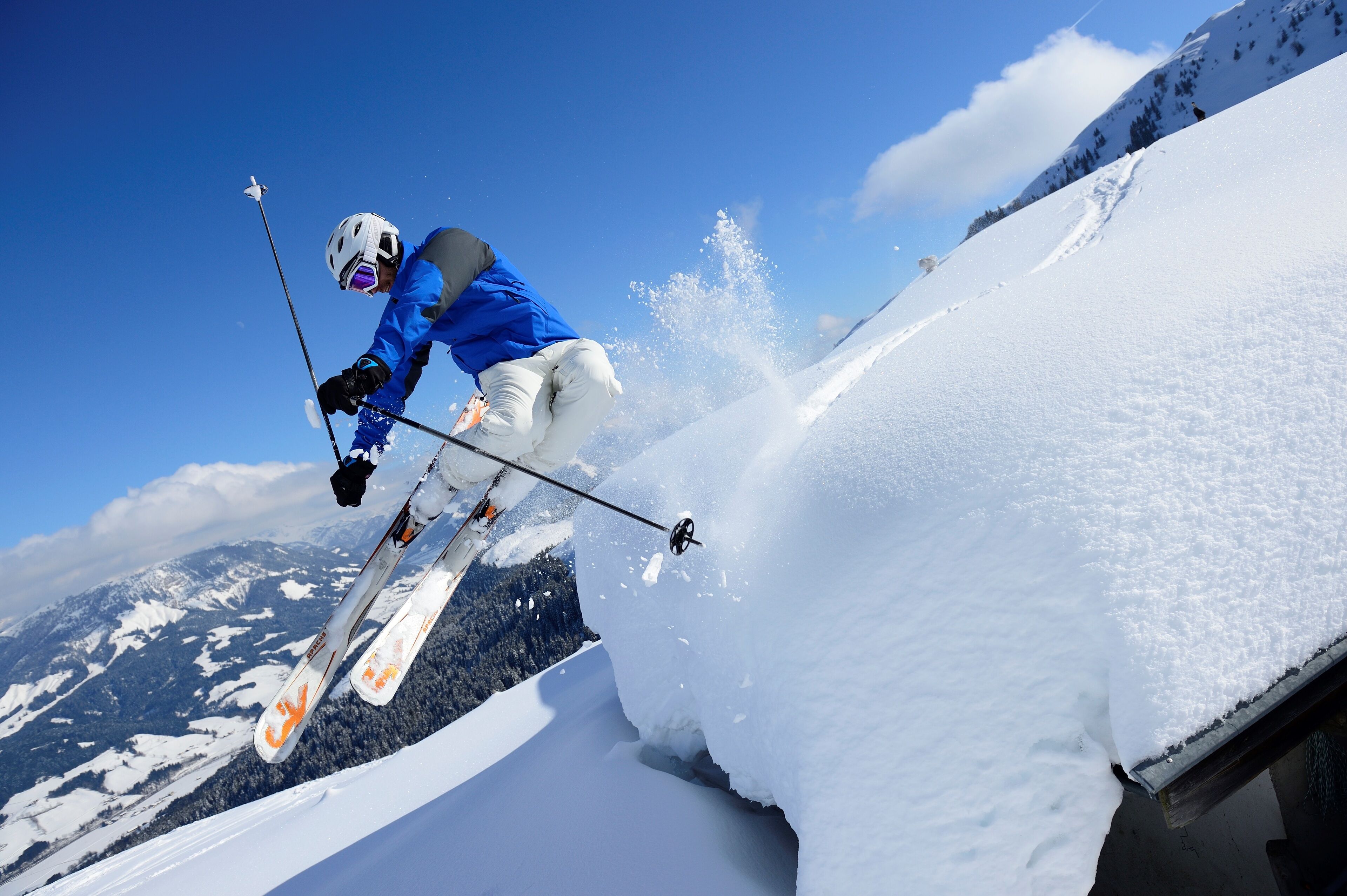 Un esquiador realizando un salto sobre una rampa de nieve.