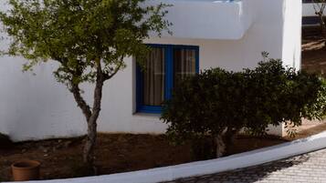 A white building with blue balconies and windows.