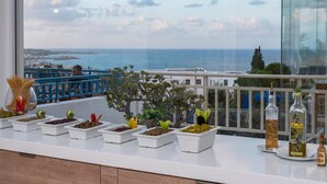 A balcony with potted plants and olive oil bottles.