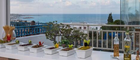 A balcony with potted plants and olive oil bottles.