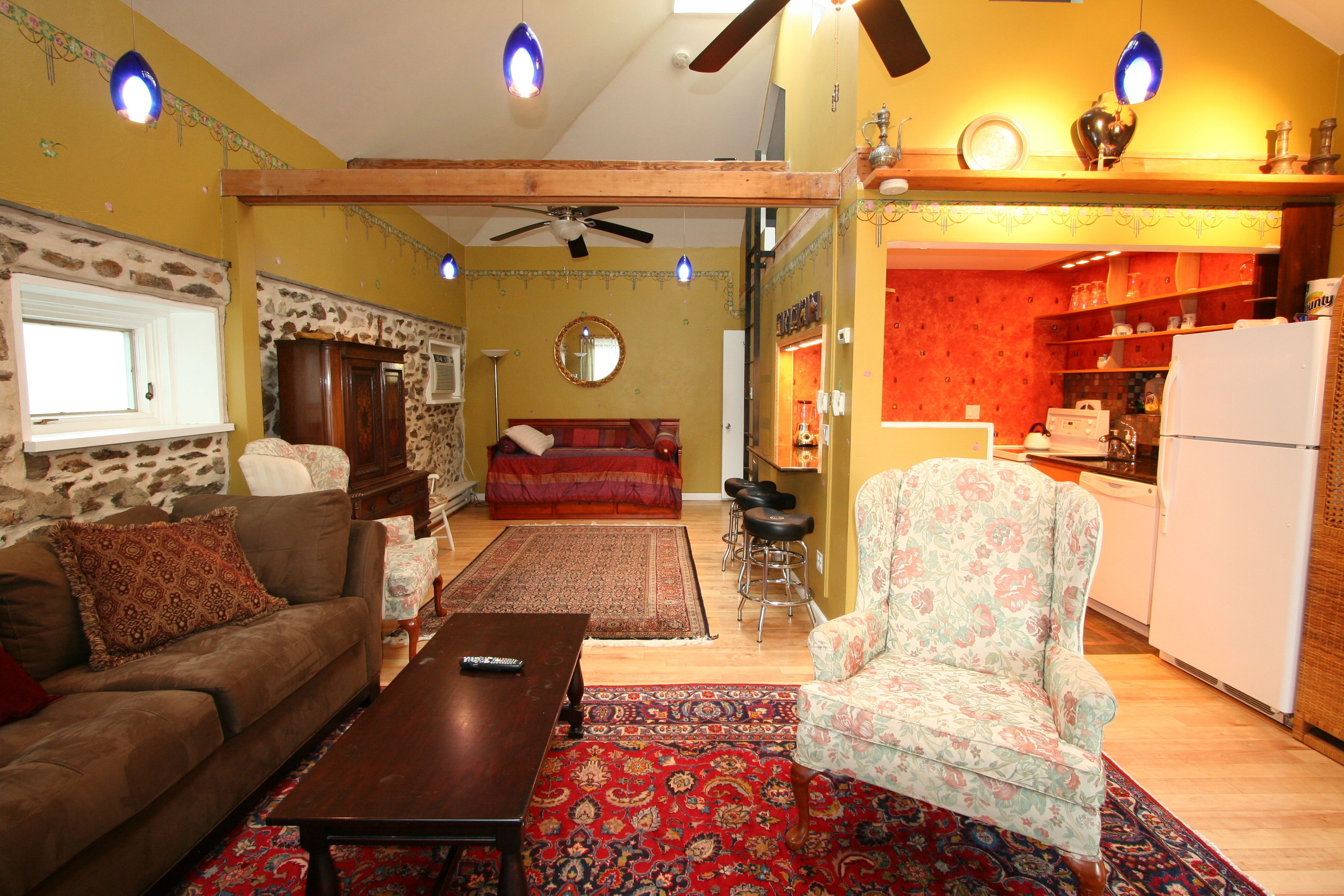 A living room with a sofa, armchair, coffee table, and a patterned rug.