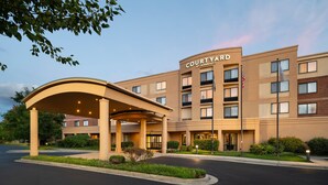 Un hôtel Courtyard by Marriott doté d’une entrée couverte, de plusieurs étages et d’un espace paysager à l’avant.