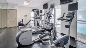 A gym with treadmills, ellipticals, and a stationary bike.