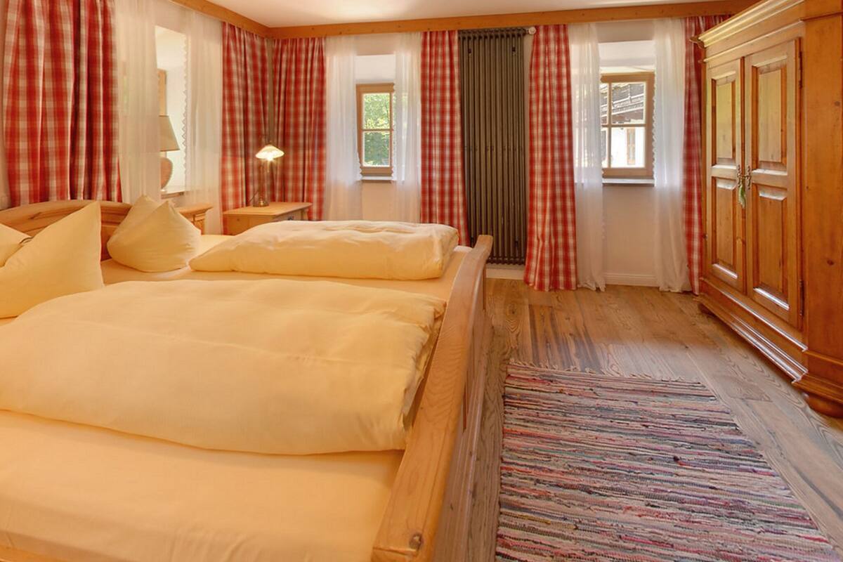 Une chambre à coucher avec un grand lit, deux tables de chevet, une lampe et une armoire.