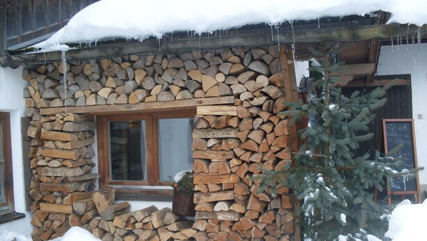 Un bâtiment rustique avec un mur en pierre et une fenêtre en bois.