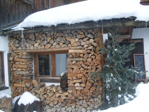 Un bâtiment rustique avec un mur en pierre et une fenêtre en bois.