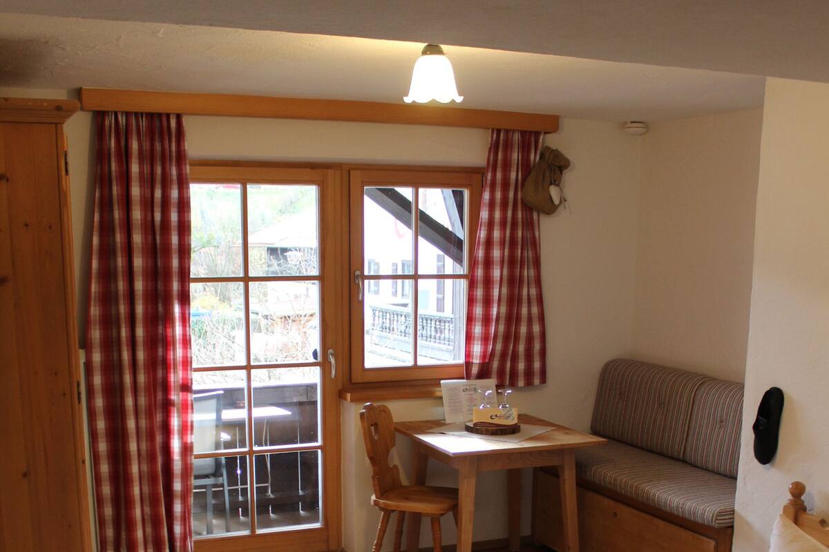 Une pièce comprenant un lit, une table, une chaise et un banc.