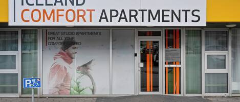 Un immeuble avec une enseigne indiquant « Iceland Comfort Apartments » et un panneau signalant l’accessibilité aux personnes à mobilité réduite.