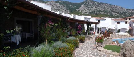 A courtyard with a stone pathway, a pool, and mountain views.