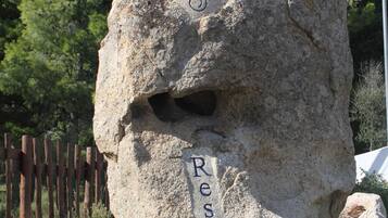 Una gran roca con inscripciones que dicen "Nuraghe Arriu Resort".