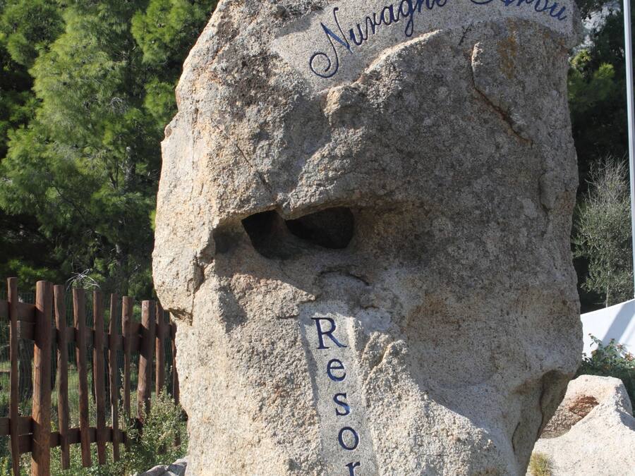 Una gran roca con inscripciones que dicen "Nuraghe Arriu Resort".