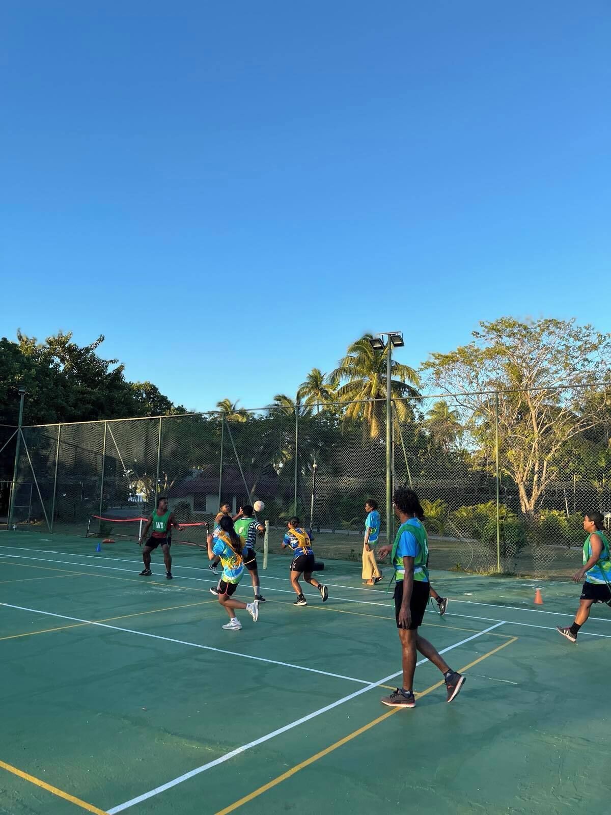 Uma quadra de tênis com jogadores trajando roupas esportivas.