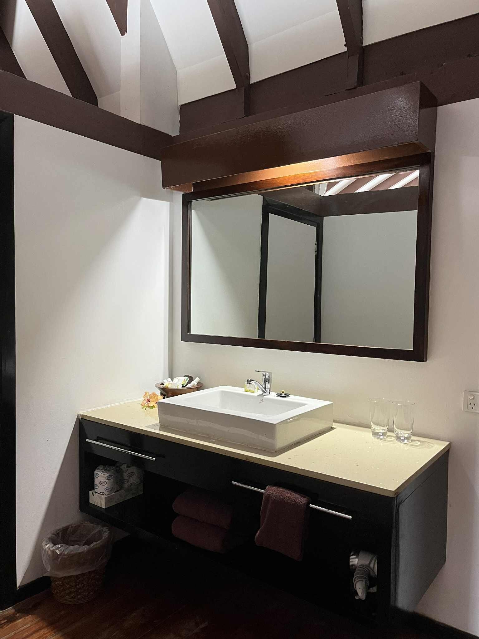 A modern bathroom with a large mirror, a sink, and a vanity.