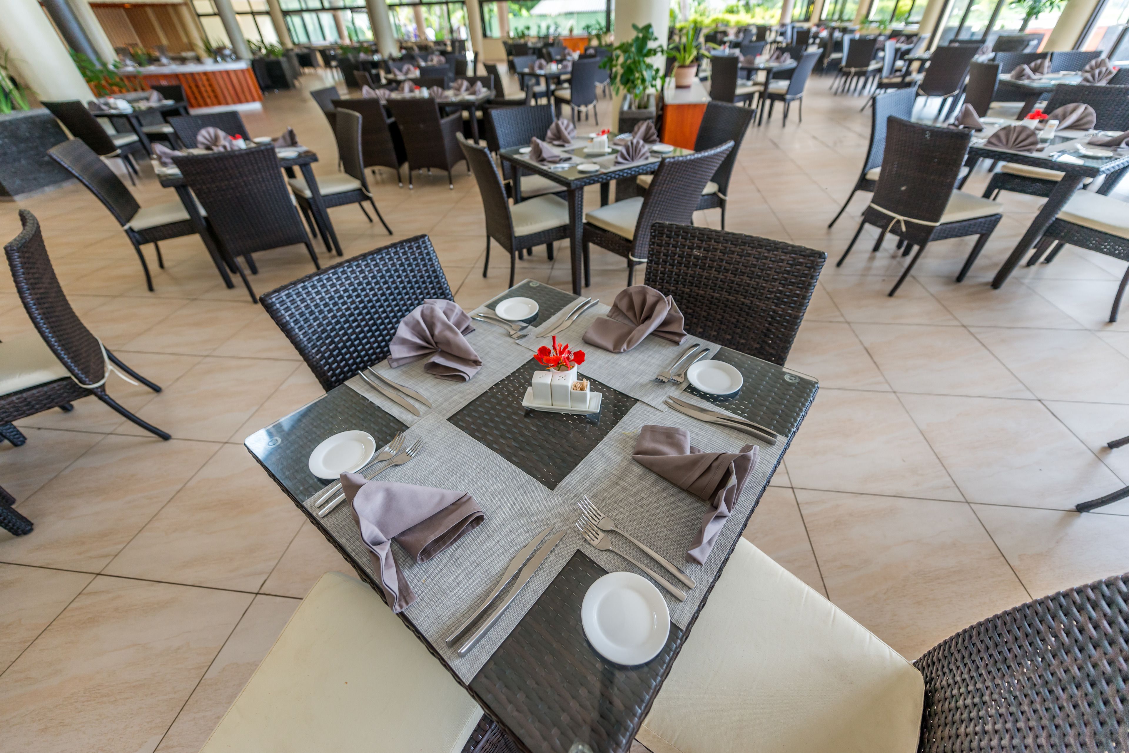 Un vaste espace intérieur aménagé pour les repas, avec de nombreuses tables, et agrémenté d’un élément décoratif central.