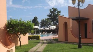 A courtyard with a swimming pool, lounge chairs, and a lamp post. - Al Canto delle Sirene (Terracina)