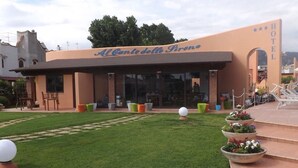 A hotel named "Al Cantio delle Sirene" with a patio area featuring outdoor seating and planters. - Al Canto delle Sirene (Terracina)