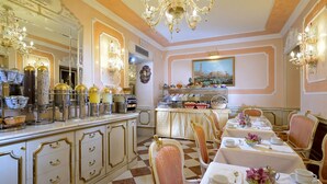 A dining area with a buffet, ornate chandeliers, and classic decor. - Hotel Canaletto (Venice)