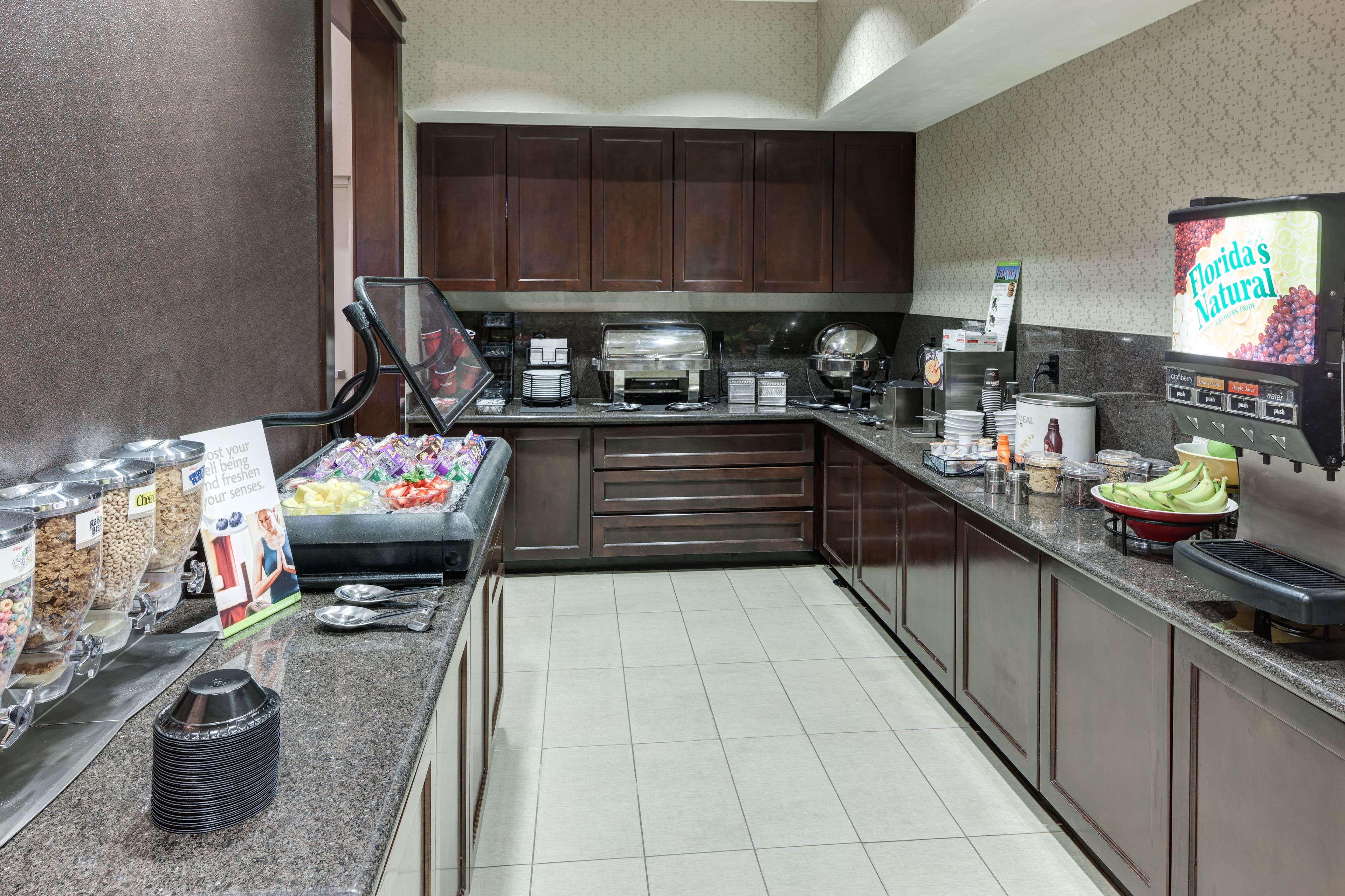 A self-service breakfast area with various food options and a beverage dispenser.
