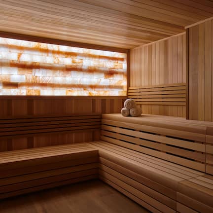 A sauna with wooden benches and a large window with a textured design.