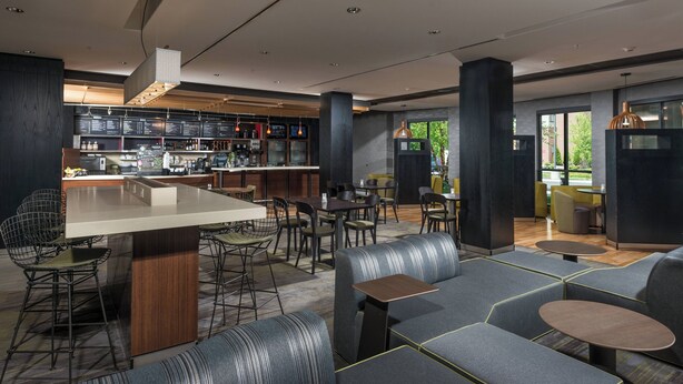 A modern restaurant with a bar area, seating arrangements, and a visible menu board. - Courtyard by Marriott Bangor (Bangor)