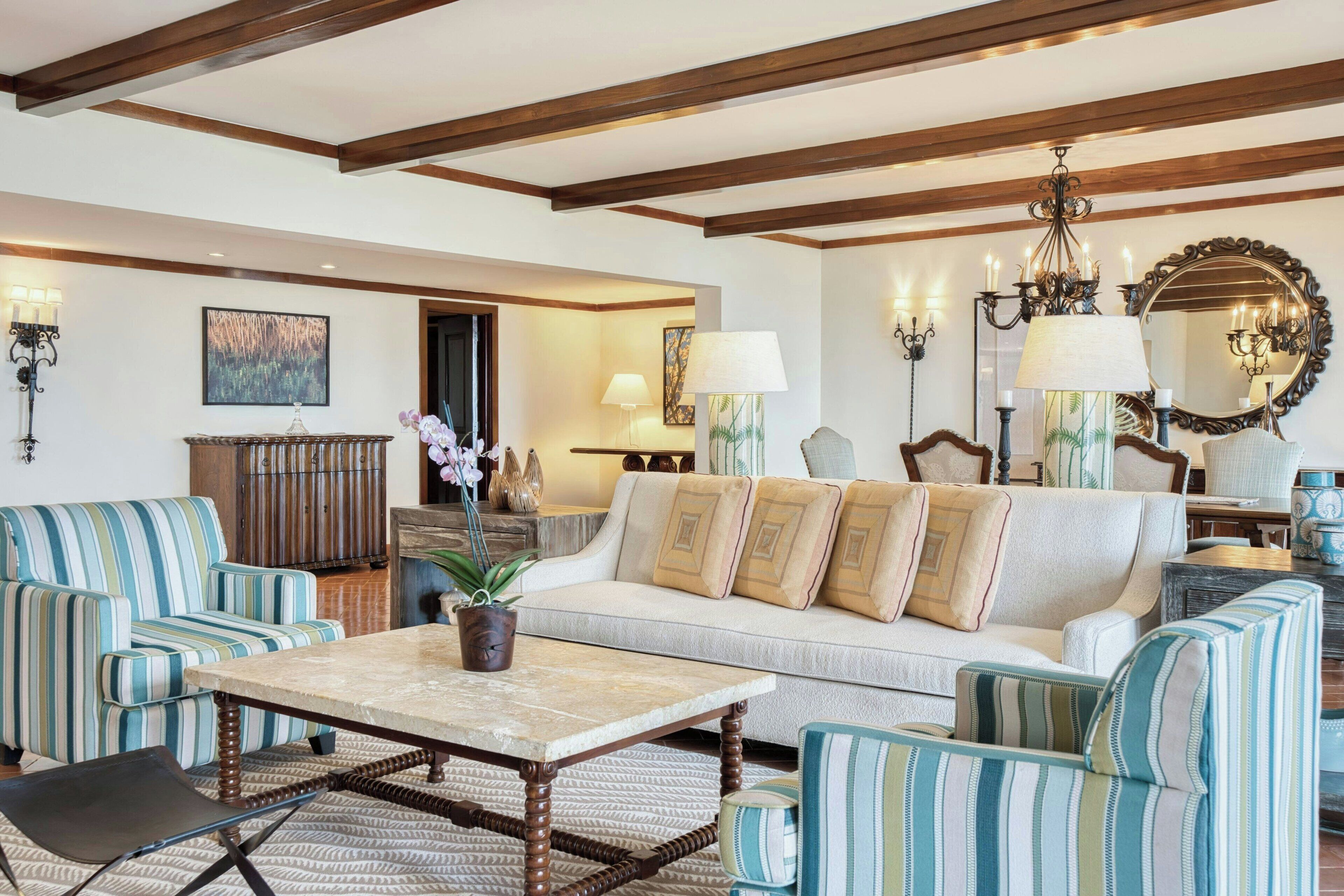 Un salon spacieux comprenant un canapé, des fauteuils, une table basse et une cheminée.