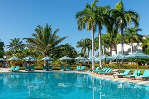 A swimming pool with lounge chairs and umbrellas, surrounded by palm trees. - JW Marriott Guanacaste Resort & Spa (Tamarindo)
