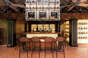 A bar area with a counter, stools, and shelves of liquor bottles.