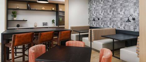 A modern interior with a bar area, seating, and a patterned wall.