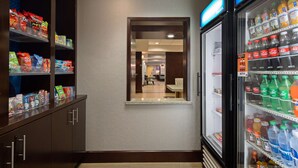 Un pasillo de hotel con una barra de aperitivos a la izquierda y un refrigerador de bebidas a la derecha.