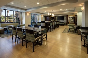 Enjoy meals in a spacious dining area with various seating options and large windows offering views of the surrounding landscape.