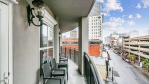 Een balkon met stoelen en uitzicht op de straat.