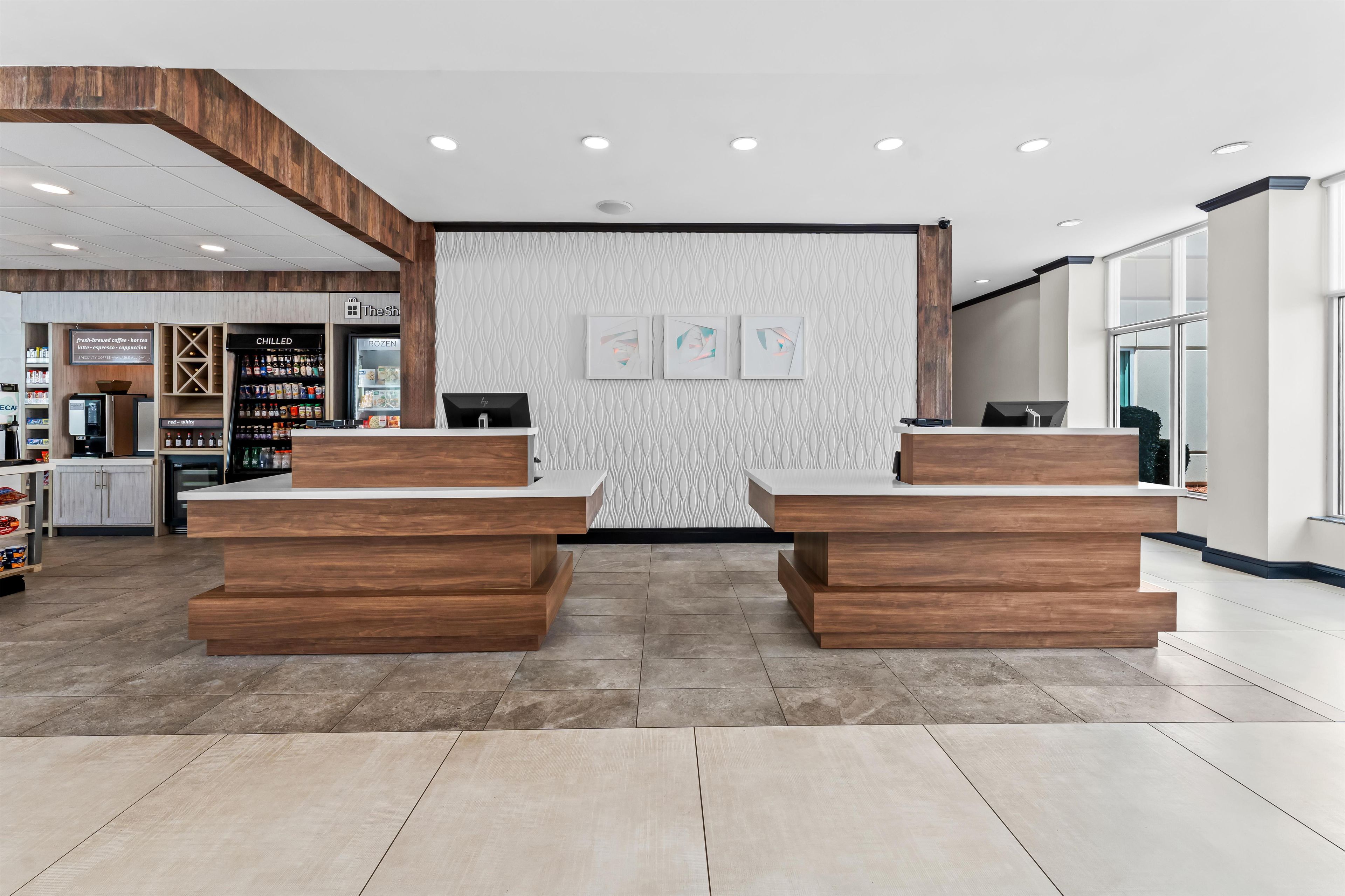 A reception area with a wooden reception desk, a wall-mounted display case, and a patterned wall.