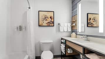 Un baño moderno con ducha, inodoro, lavabo y toallero.