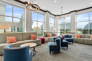 A spacious lounge area with a large sofa set, multiple armchairs, and a round table.