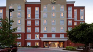 A multi-story hotel with a prominent entrance, multiple windows, and a sign indicating it is a Homewood Suites Hilton. - Homewood Suites Fort Wayne (Fort Wayne)
