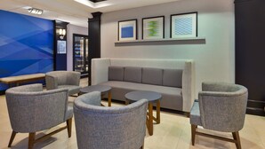 A modern lounge area with a sofa, armchairs, and a small table. - Holiday Inn Express & Suites Warminster - Horsham by IHG (Warminster)