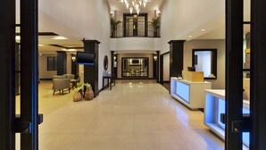 A spacious lobby with a high ceiling, a central staircase, and a reception desk. - Holiday Inn Express & Suites Warminster - Horsham by IHG (Warminster)